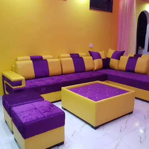 Living room built around a purple velvet and yellow leatherette L-sofa with matching stools and box centre table