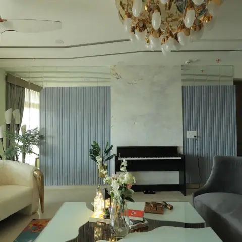 Living room built around an upright piano set against a marble slab panel flanked by powder-blue fluted panelling, with a gilt-legged ivory settee