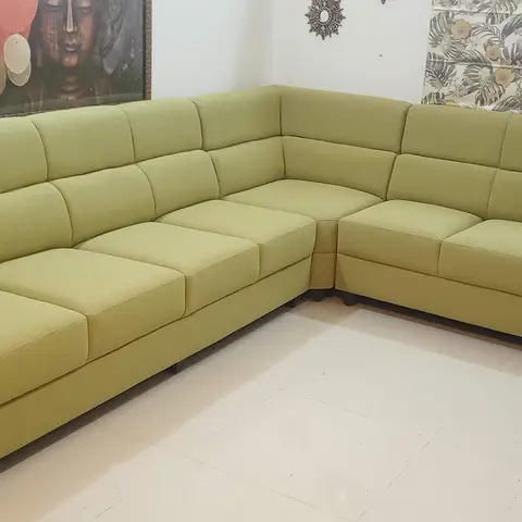 Living room corner with a large olive-green L-shaped sectional sofa beneath a framed Buddha wall art