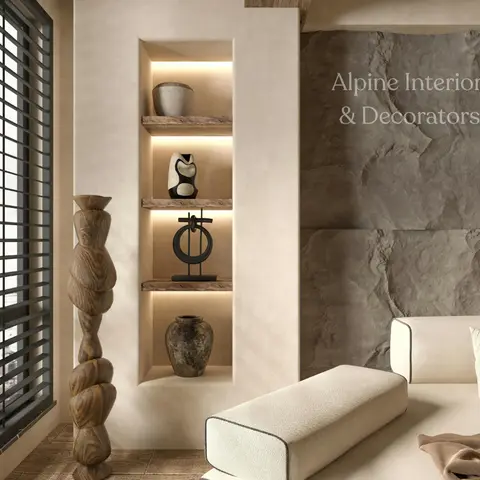 Living room corner with a rugged stone-clad accent wall beside a plaster niche of backlit display shelves styled with ceramic and stone vessels