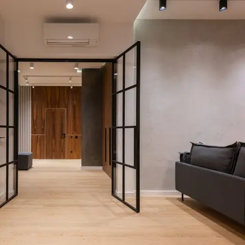 Living room corner with a textured plaster feature wall holding a carved decorative panel, a charcoal sofa