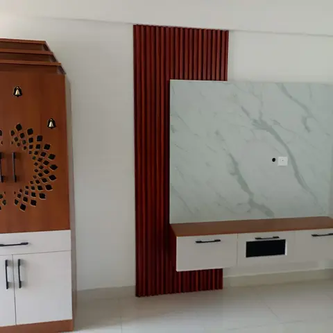 Living-room feature wall with a floating TV console under marble-effect cladding beside a red fluted panel strip