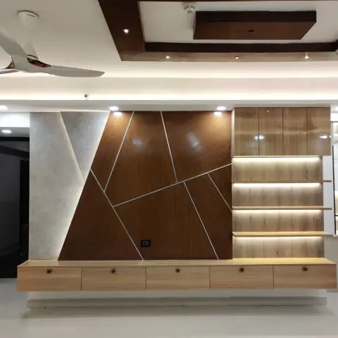 Living room feature wall with angular wood-and-stone geometric panelling, backlit floating wood shelving, and a wall-mounted floating console below.