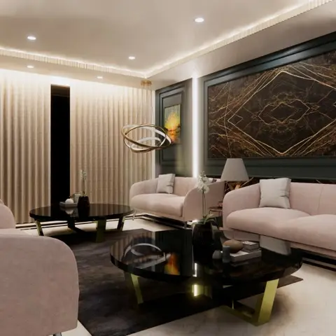 Living room in dark green panelled walls with a black-and-gold marble slab wall art piece, blush pink sofas and armchair around dual black round coffee tables