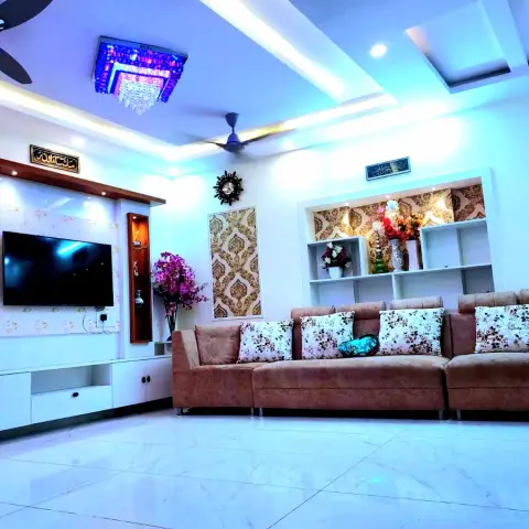 Living room lit blue by its cove LEDs, with a damask-wallpapered TV panel between two lit vertical curio niches