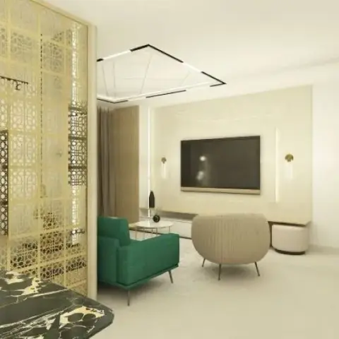 Living-room render screened by a floor-to-ceiling brass jaali, an emerald armchair and a ribbed cream tub chair facing a TV on a textured panel flanked by slim