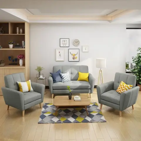 Living room set of a grey two-seater flanked by two matching armchairs on pale beech legs, mustard and chevron cushions