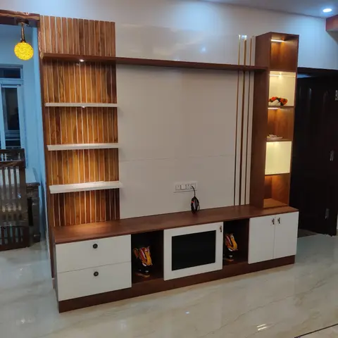 Living room TV feature wall combining vertical wood fluting with a glossy white panel and a lit display niche column holding decorative figurines.