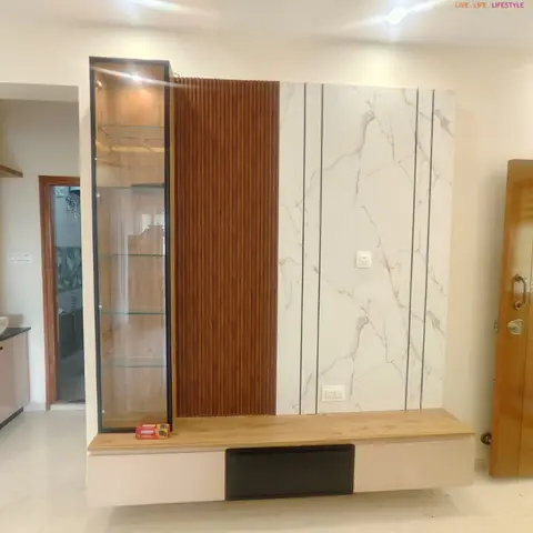 Living room TV feature wall combining a fluted wood panel strip and marble-look tile cladding