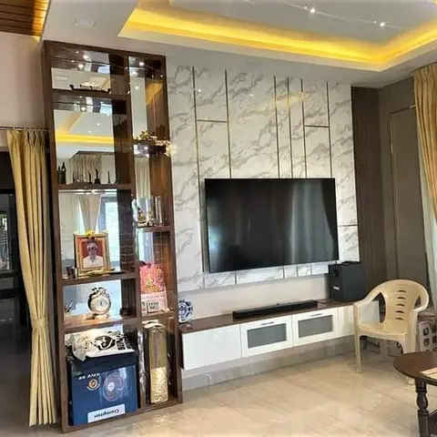 Living room TV feature wall in book-matched grey marble with brass inlay strips, a cove-lit ceiling with fairy lights