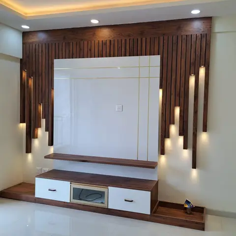 Living room TV feature wall of staggered dark wood fluted battens with backlighting flanking a gold-lined glossy panel and a two-tone TV console
