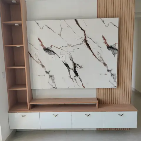 Living room TV feature wall with a large white-and-grey marble-effect slab panel flanked by vertical fluted wood cladding and an open ladder shelf