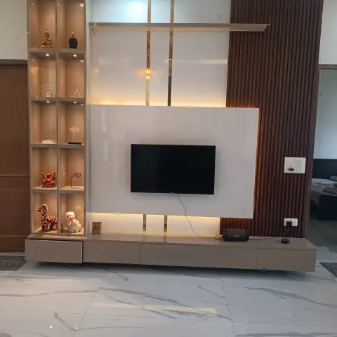 Living room TV feature wall with a glossy white panel and brass inlay strips beside fluted wood cladding