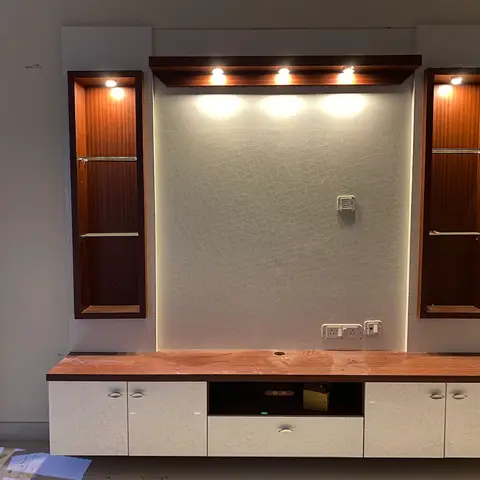Living room TV feature wall with crocodile-textured white wallpaper, a spotlighted pelmet above, twin wood-veneer display niches with glass shelves