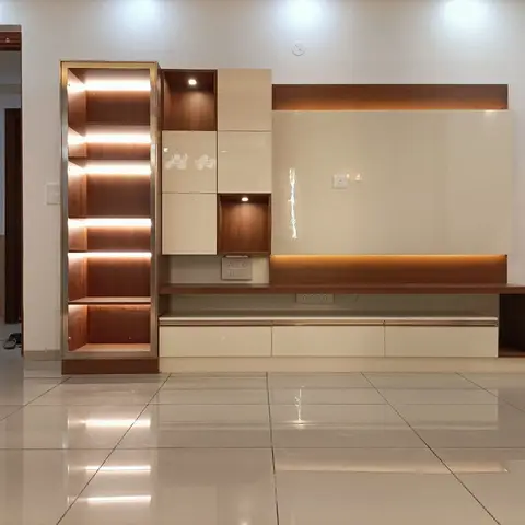 Living room TV feature wall with a tall backlit display cabinet, two-tone cream and walnut lacquer panels, and a floating drawer console below the TV.