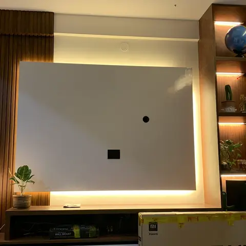 Living room TV feature wall with fluted wood panelling and a backlit blank panel awaiting the TV mount