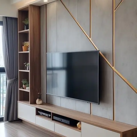 Living room TV feature wall with gold geometric inlay on a grey stone panel, wood open shelving and a floating media console