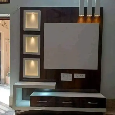Living room TV unit wall with three individually lit display niches, a white TV backing panel, and a floating console with blue LED under-lighting.