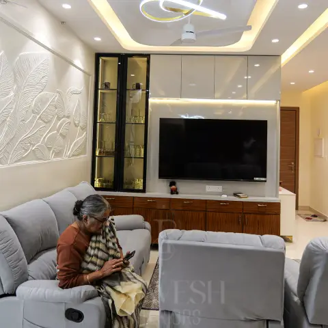 Living room TV unit with a glass-front crockery display, a textured botanical leaf wall panel