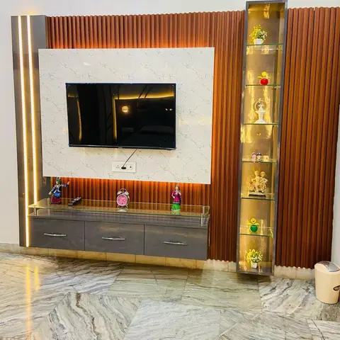 Living room TV unit with a white marble-effect panel on a wood fluted slat wall and a tall backlit glass curio display of figurines beside it