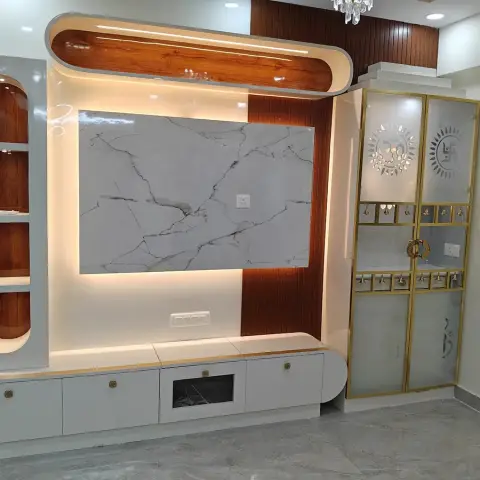 Living-room TV wall at handover: a backlit white marble slab framed by rust-toned grooved wood panelling under a curved capsule soffit