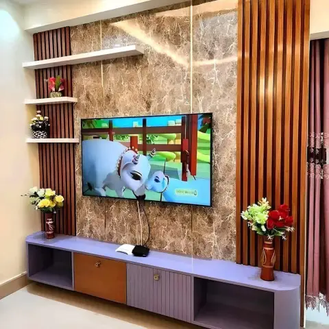 Living room TV wall clad in brown-veined marble panels flanked by vertical wood fluting, with a floating purple-grey TV console and floral vases on either side.