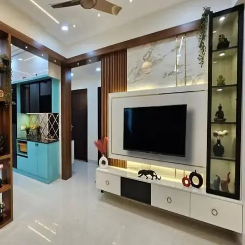 Living room TV wall combining a marble-look upper panel with brass inlays, a teak fluted band and a backlit white TV surround