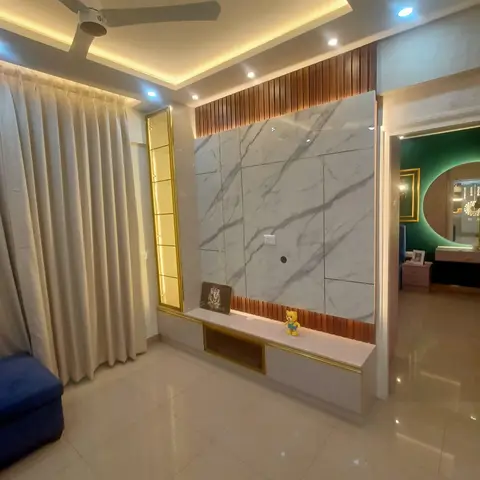 Living room TV wall in book-matched grey-veined marble with copper fluted trim and a gold-lit vertical display niche