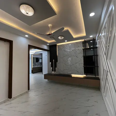 Living room TV wall in book-matched white-and-grey marble slab flanked by a black metal ladder shelf
