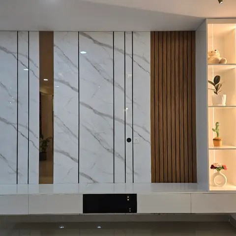 Living-room TV wall in large-format marble-effect panelling with a concealed door and a fluted wood accent strip