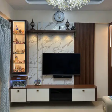 Living-room TV wall in white marble-look slab cladding with thin brass inlay strips, a fluted walnut panel to the right