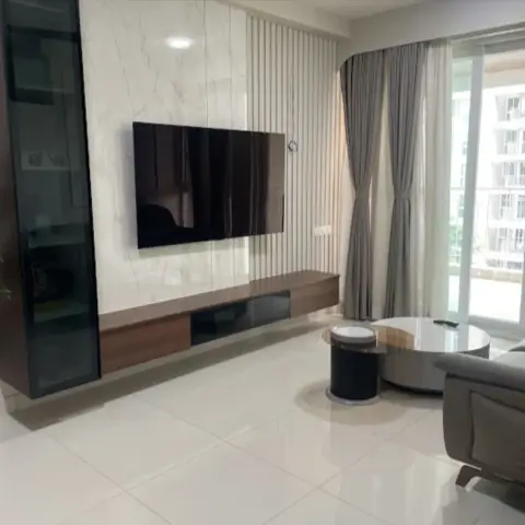 Living room TV wall split between a white marble-look slab and white fluted panelling, with a walnut floating console under the screen