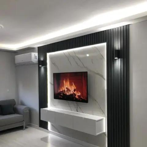 Living-room TV wall where black fluted panels frame a white marble slab floated off the wall on an LED shadow gap