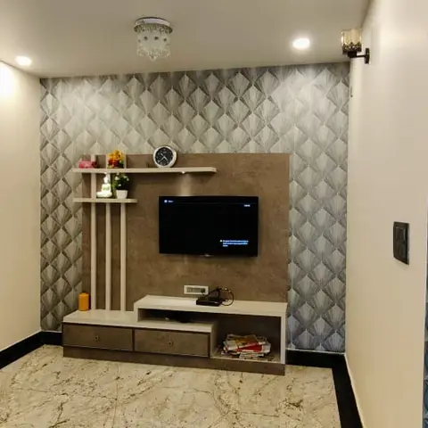Living room TV wall with a grey diamond-patterned wallpaper backdrop, a floating wood-tone TV console with drawer storage, and a decor ledge above.