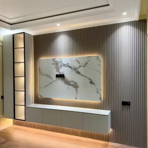 Living room TV wall with a backlit book-matched marble slab set into fluted grey wall panelling above a floating grey console with a lit display shelf