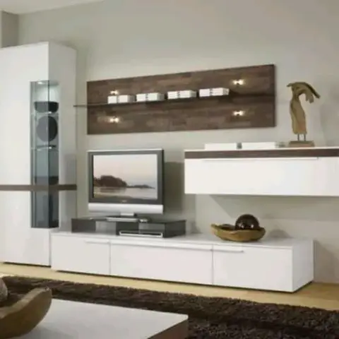 Living room TV wall with a white gloss floating console and wall-mounted cabinet beside a dark wood-effect accent panel with shelf lighting and a tall glass