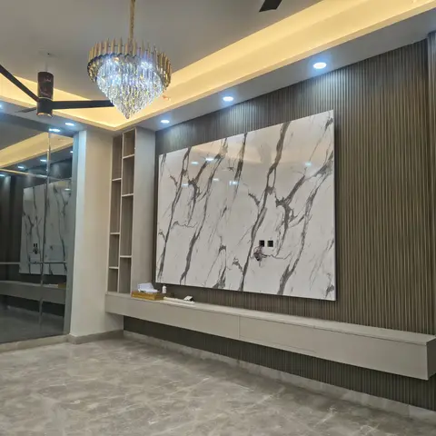 Living room TV wall with a bookmatched marble slab panel flanked by dark fluted wood panelling and open display niches, a floating stone-top console below