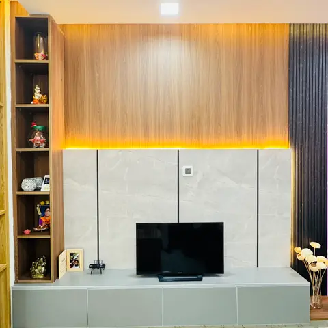 Living room TV wall with a backlit wood-veneer panel over marble-look stone cladding, a floating grey console