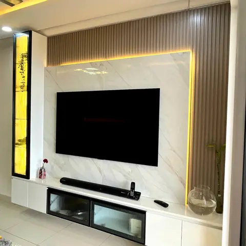 Living room TV wall with a backlit marble panel framed by taupe fluted cladding, a floating white unit with fluted-glass cabinet doors, and a cove-lit ceiling