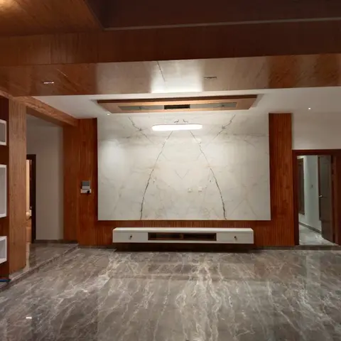 Living room TV wall with a large book-matched marble slab flanked by fluted wood columns, a wood-clad ceiling and a floating fluted-front console.