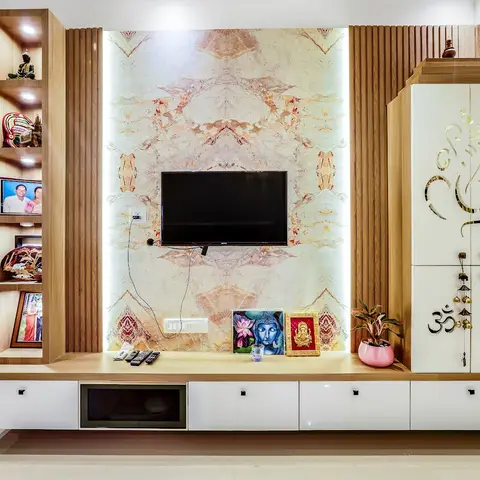 Living room TV wall with a backlit book-matched marble panel, a display niche of family photos and figurines on one side