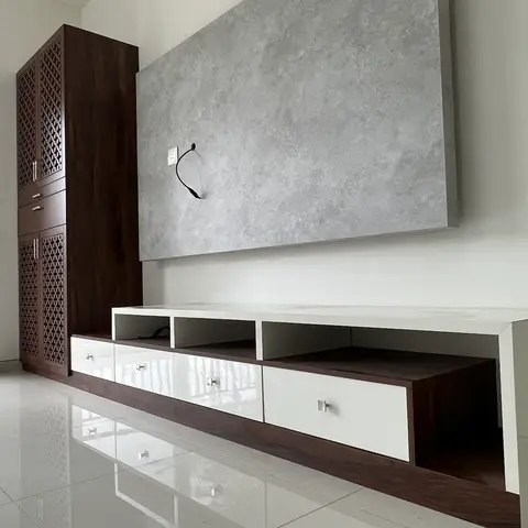 Living room TV wall with a textured concrete-look stone panel, a long white and walnut TV console with open cubbies and drawers
