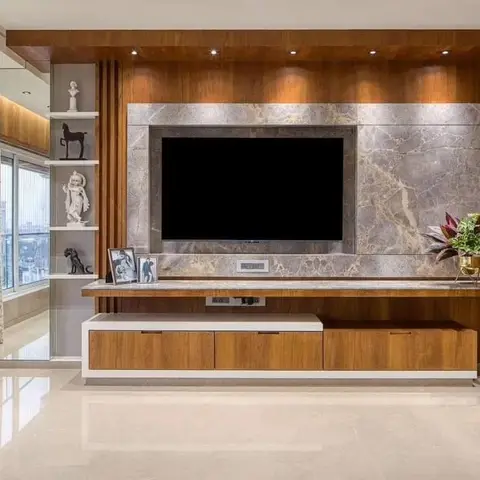 Living room TV wall with a book-matched marble panel set into a warm wood surround, over a floating two-tone console with a statue display niche.