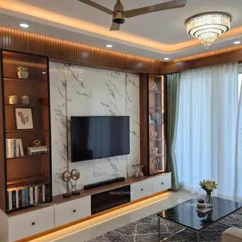 Living room TV wall with a book-matched marble panel and gold-veined inlay flanked by backlit fluted-wood display shelves