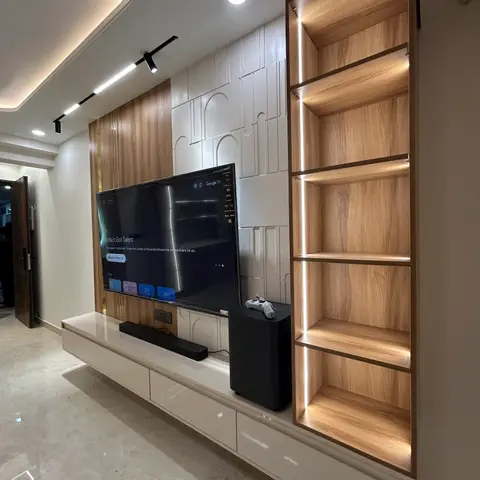 Living room TV wall with a floating white gloss console, a 3D arch-textured feature panel, and a backlit open wood shelving unit.