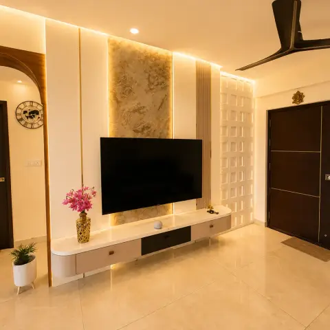 Living room TV wall with a backlit onyx marble panel and a perforated jaali block screen beside a dark wood main door