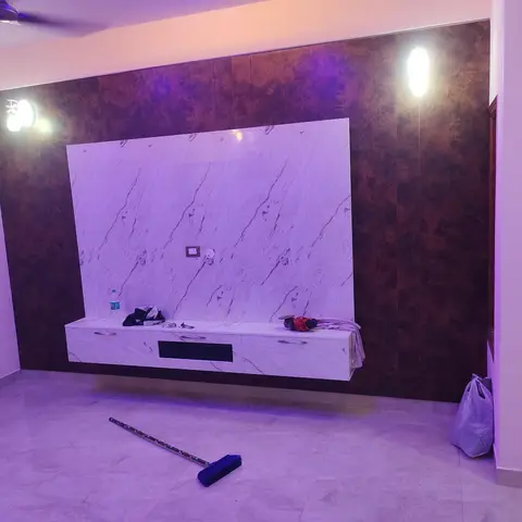 Living room TV wall with a brown marble-effect laminate surround and a white marble-pattern panel and floating console below.