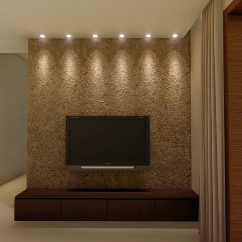 Living room TV wall with a textured stone-look feature wall washed by a row of downlights, a floating dark-wood console below