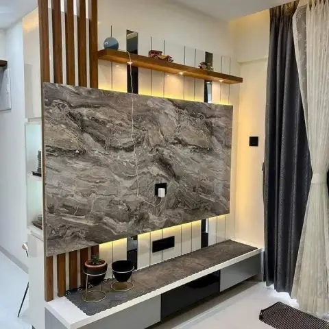 Living room TV wall with a grey-veined marble panel between vertical wood slats, a backlit display shelf above, and a floating grey stone-top console below.