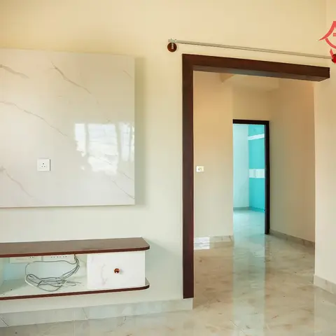 Living room TV wall with a large book-matched marble slab backdrop and a floating wood-and-white media console, still without a mounted TV.
